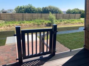 a balcony with a railing with a view of a river at Chapel Fields Holiday Park in Chapel Saint Leonards