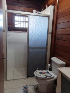 a bathroom with a toilet and a glass shower at Casa de campo na cidade in São José