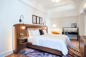 a bedroom with a large white bed and a desk at The Benjamin Royal Sonesta New York in New York