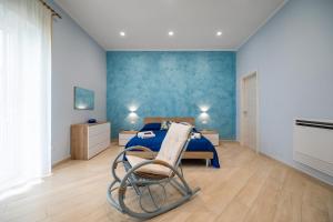 a bedroom with a bed and a chair in it at Camerelle Apartments - casa vacanze in Castellammare di Stabia
