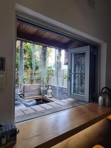 a door to a patio with a dog sitting on the porch at What’s behind the green door! in Cape Town