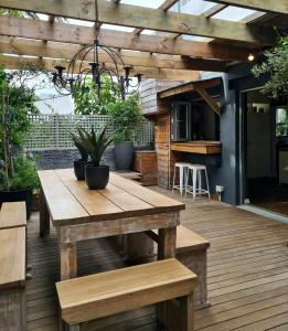 a wooden deck with a wooden table and benches at What’s behind the green door! in Cape Town