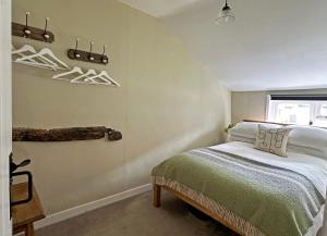 a bedroom with a bed and a window with hangers at Lavender Cottage, Clare in Clare
