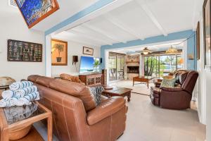 een woonkamer met leren banken en een televisie bij Island Sea-Cret in Anna Maria