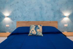 a bedroom with a blue bed with a pillow on it at Camerelle Apartments - casa vacanze in Castellammare di Stabia