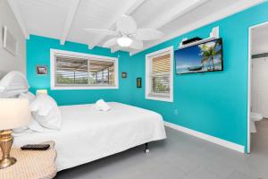 een blauwe slaapkamer met een bed en een plafondventilator bij Island Sea-Cret in Anna Maria +80 foto's