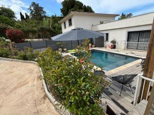 a backyard with a swimming pool and an umbrella at Villa 3 chambres avec piscine privative in Ajaccio