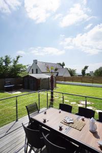 una mesa en una terraza con vistas a un campo en Villa Anne - 500m de la mer - SPA, en Moëlan-sur-Mer