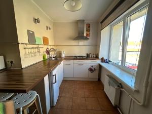 een keuken met witte kasten en een groot raam bij Butas prie vaikų parko in Ventspils