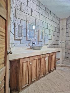 Un baño con lavabo y pared de ladrillo. en Finca Agua Salada, en Xochitepec 30 fotos más