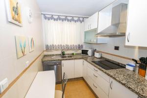 a small kitchen with white cabinets and a sink at Apartment Mountain View in Torrox +4 photos