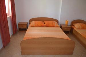 two beds with orange pillows in a room at Apartmants Bubalo in Trpanj