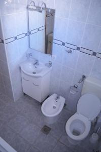 a white bathroom with a toilet and a sink at Apartmants Bubalo in Trpanj