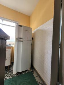 eine Küche mit Kühlschrank in der Ecke eines Zimmers in der Unterkunft Apartamento a uma quadra do mar - Bairro Itapuã in Vila Velha