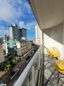 einen Balkon mit Blick auf eine Stadtstraße in der Unterkunft Apartamento a uma quadra do mar - Bairro Itapuã in Vila Velha