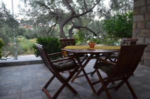 a wooden table and chairs on a patio at Apartmants Bubalo in Trpanj