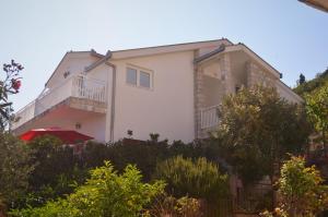 a white house with a balcony on the side of it at Apartmants Bubalo in Trpanj
