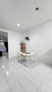 a white room with a table and a white tiled floor at AZ homestay KLIA in Banting