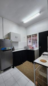 a kitchen with a refrigerator and a table at AZ homestay KLIA in Banting