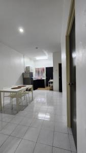 a living room with a table and a white tile floor at AZ homestay KLIA in Banting