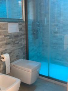 Un baño con inodoro y ducha de cristal. en FronteMare Luxury, en Montesilvano