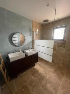 a bathroom with two sinks and a mirror at Route des châteaux in Ribagnac