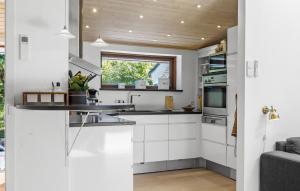 a kitchen with white cabinets and a window at Awesome Home In Græsted With Sauna in Græsted