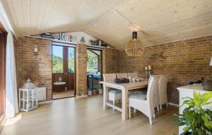 a dining room with a table and a brick wall at Awesome Home In Græsted With Sauna in Græsted