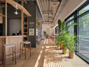a hallway with chairs and plants in a building at STAYERY Gütersloh Hauptbahnhof & City Center - alle Zimmer mit Klimaanlage in Gütersloh
