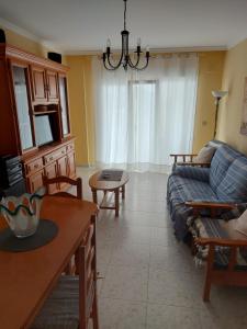 una sala de estar con un sofá y una mesa en Vivienda PLAYA DE ALTAR, en Barreiros