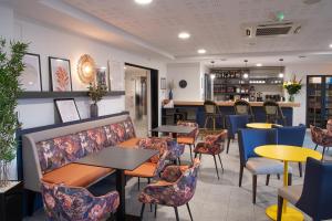 a restaurant with tables and chairs and a bar at Domitys Les Sources de Gascogne in Dax