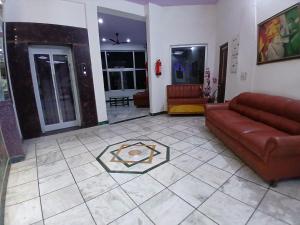 a living room with a brown couch and a tile floor at Hotel Taj Plaza, VIP Road, Agra in Agra
