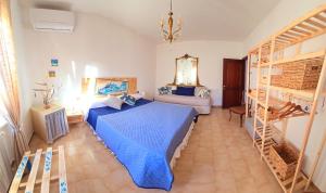 una camera con letto blu e scala di La casa di Mamma, Appartamento di charme nel borgo a Luogosanto