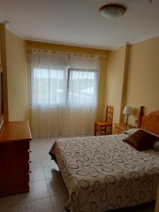 un dormitorio con una cama y una ventana en Vivienda PLAYA DE ALTAR, en Barreiros