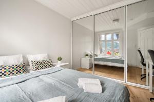 een witte slaapkamer met een groot bed en een raam bij Charming apartment with stunning views! in Bergen