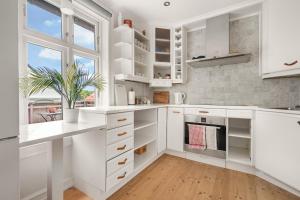 een keuken met witte kasten en een potplant bij Charming apartment with stunning views! in Bergen