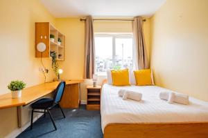 Una habitación de hotel con una cama, un escritorio y una ventana. en 54 - Large Three Bed Apt with Parking, en Galway