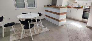 una cucina con tavolo bianco e sedie nere di Sofija's Home a Negotino