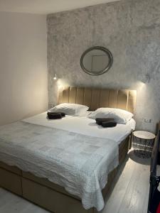 a bedroom with a large bed with a mirror on the wall at Apartments Oliva in Poreč