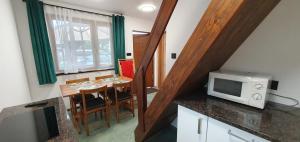 a small kitchen with a table and a microwave at Domki letniskowe "U Adaska" in Chałupy
