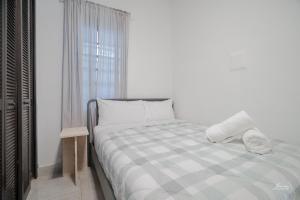 Una habitación blanca con una cama y una ventana en SAN JUAN Villa - Laplacita, en San Juan