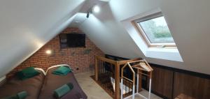 a room with a staircase with a couch and a window at Domki letniskowe "U Adaska" in Chałupy