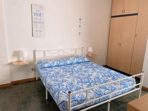 a bedroom with a bed with a blue comforter at Appartamento con piscina a 100metri dal mare in Castiglioncello