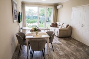 a living room with a table and chairs and a couch at Garden Apartment Fichoza 2 - 80m from the sea in Varna City +16 photos