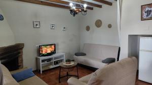 a living room with a couch and a tv at Casa Villazo 2 in Málaga