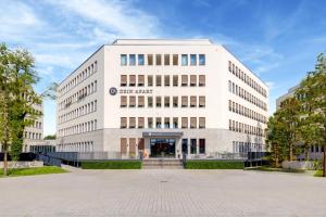 a large white building with the entrance to it at DEIN APART München in Munich