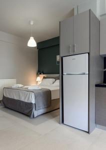 ein Schlafzimmer mit einem Bett und einem weißen Kühlschrank in der Unterkunft MvP PAL in Preveza