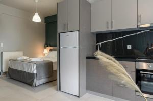eine Küche mit einem weißen Kühlschrank und einem Bett in der Unterkunft MvP PAL in Preveza + 6 Fotos
