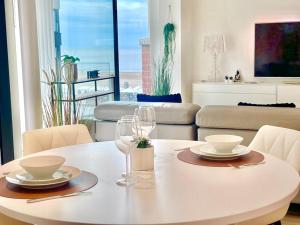 a white table with two wine glasses and a living room at Luxury Suite Koksijde 210 - Adult only in Koksijde