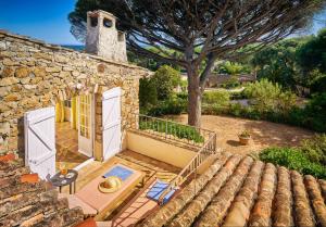 an external view of a stone house with a patio at La Ferme D'Augustin in Saint-Tropez